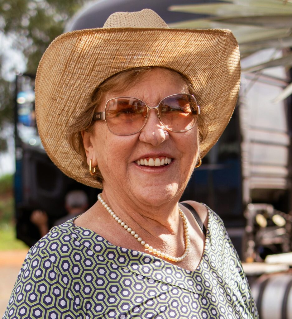 Cheerful senior woman wearing a sun hat and sunglasses outside in rural Brazil.