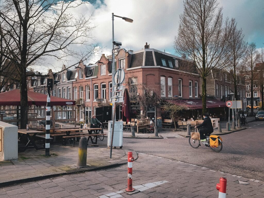 A quiet winter day in Amsterdam featuring a cyclist passing by a quaint street corner.